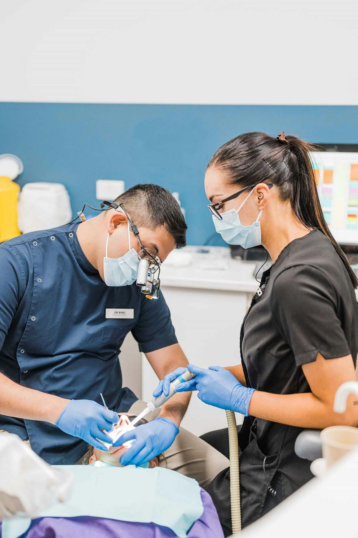 Dos profesionales dentales atendiendo a un paciente