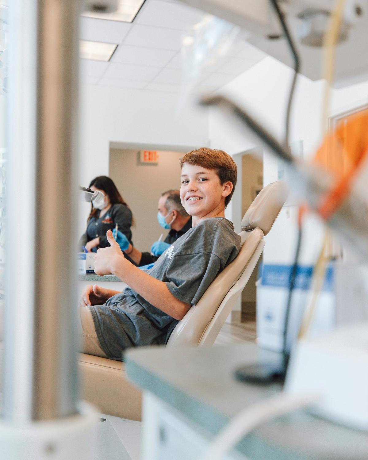 Paciente sonriente sentado en el sillón dental