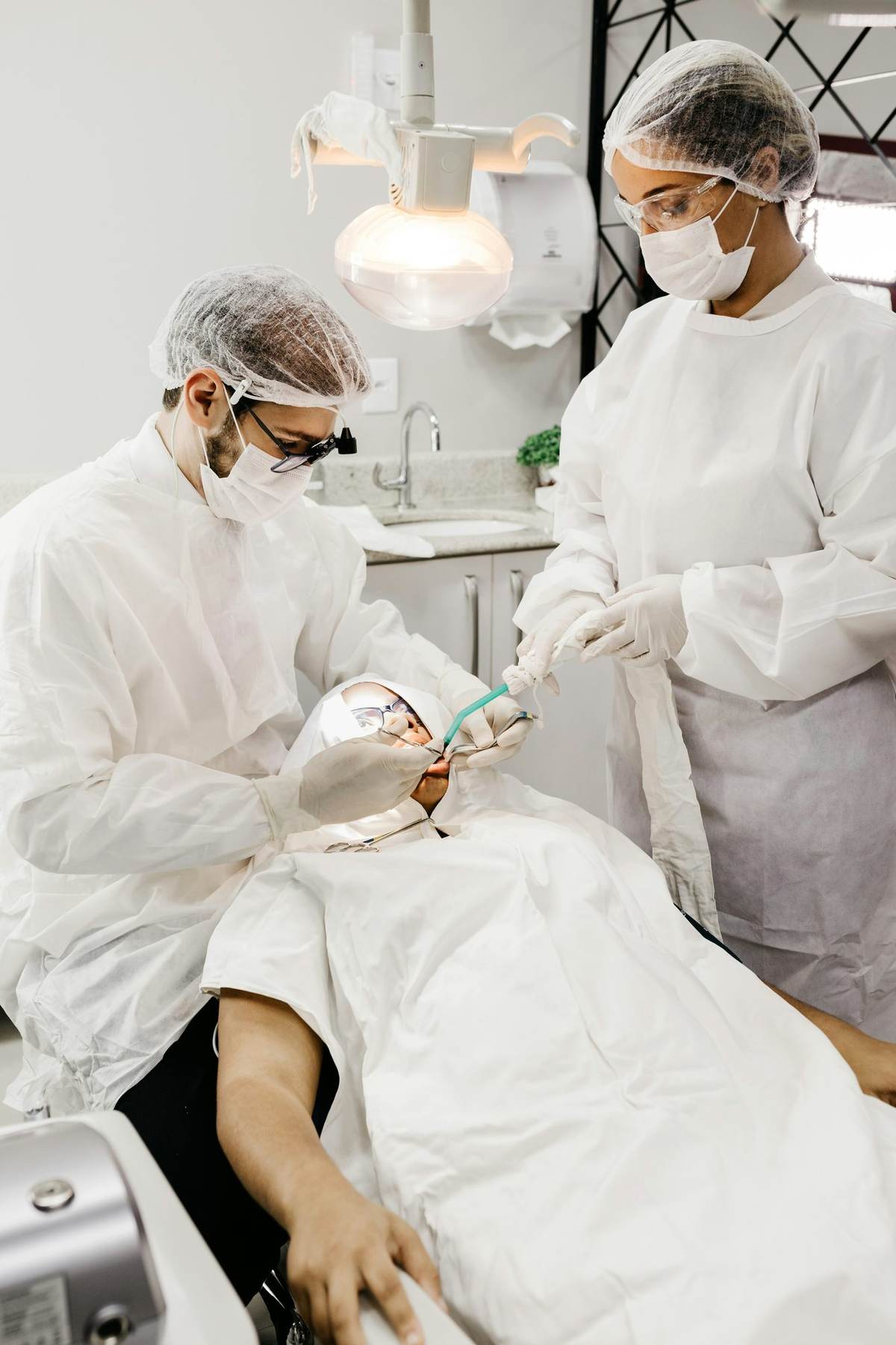 Profesionales dentales atendiendo a un paciente en el sillón